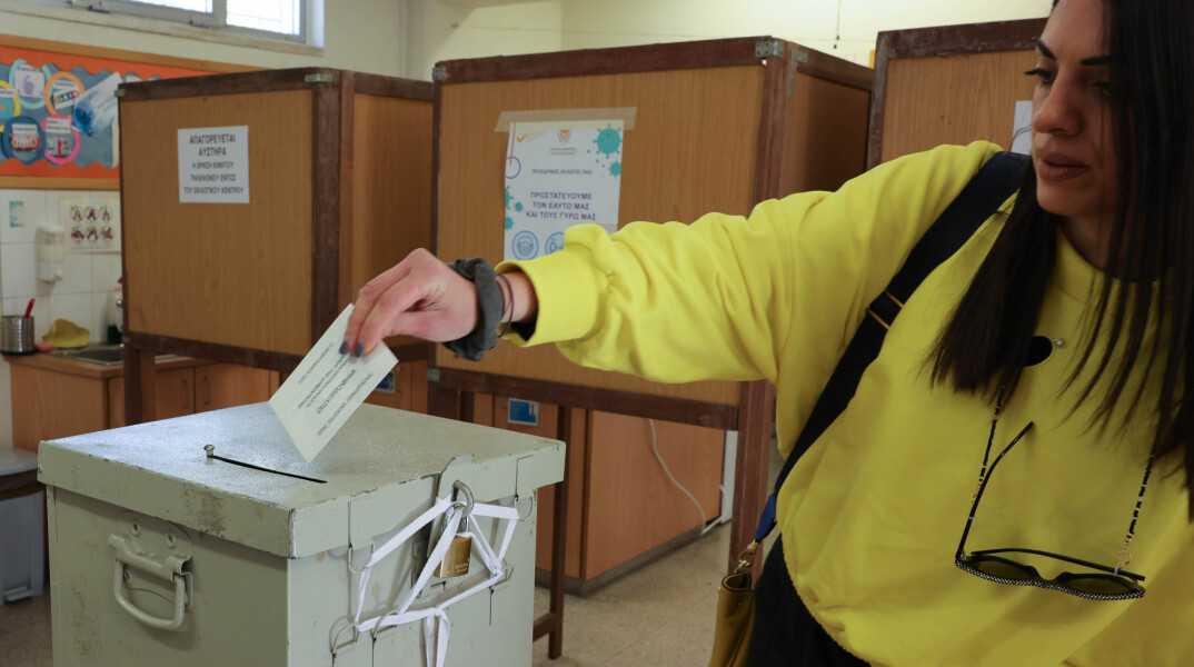 Γυναίκα προσέρχεται στην κάλπη και πετά το ψηφοδέλτιο της για την ανάδειξη του νέου Προέδρου της Κυπριακής Δημοκρατίας