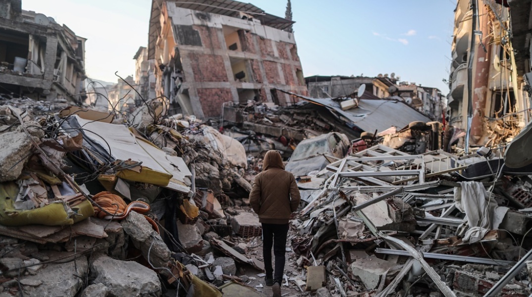 Πολίτης περπατά ανάμεσα στα χαλάσματα μετά τον σεισμό στην Τουρκία