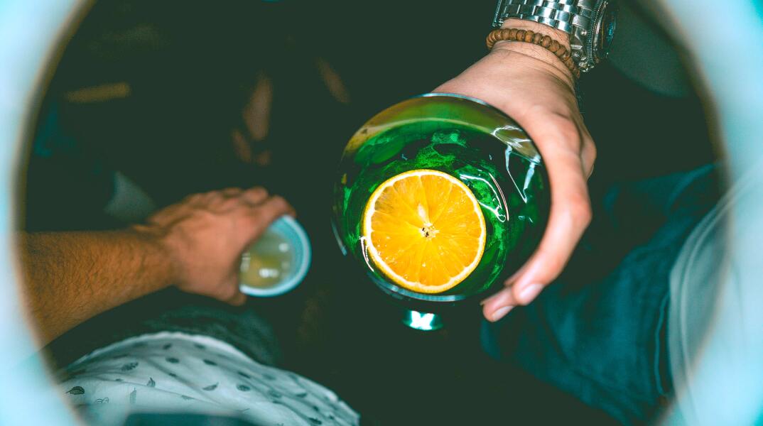 Έφηβοι κρατούν ποτήρια με ποτά κατά τη διάρκεια νυχτερινής τους εξόδου σε μπαρ