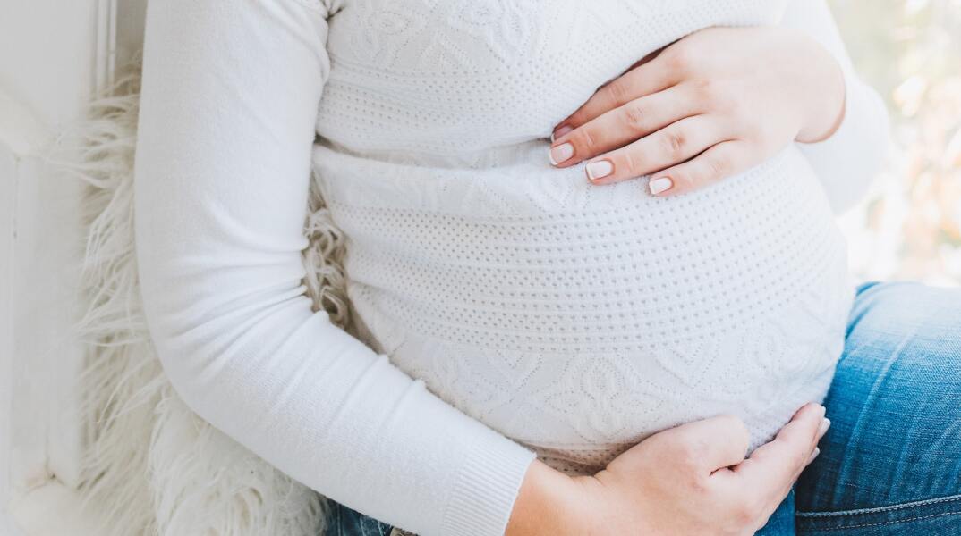Έγκυος κρατά προστατευτικά και τρυφερά την κοιλίτσα της