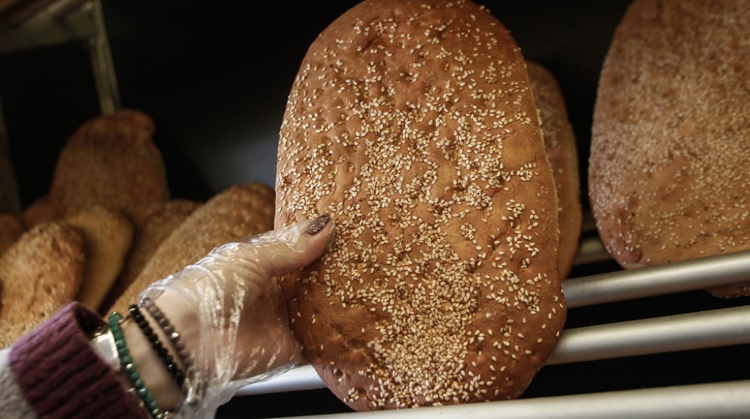 Χέρι αρτοπώλη κρατά λαγάνα