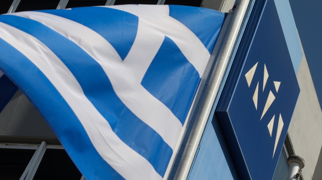 Το λογότυπο της Νέας Δημοκρατίας και η ελληνική σημαία έξω από τα γραφεία του κόμματος στην Πειραιώς
