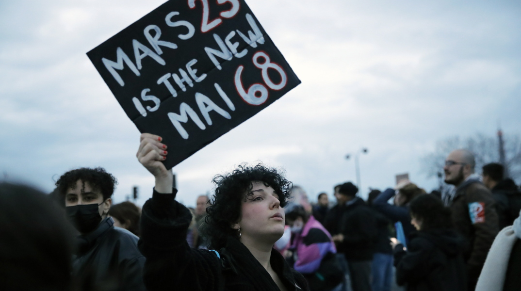 Διαμαρτυρίες και διαδηλώσεις στη Γαλλία για τη συνταξιοδοτική μεταρρύθμιση - Γυναίκα με πλακάτ που γράφει: «Ο Μάρτης του 2023 είναι ο νέος Μάης του 1968»