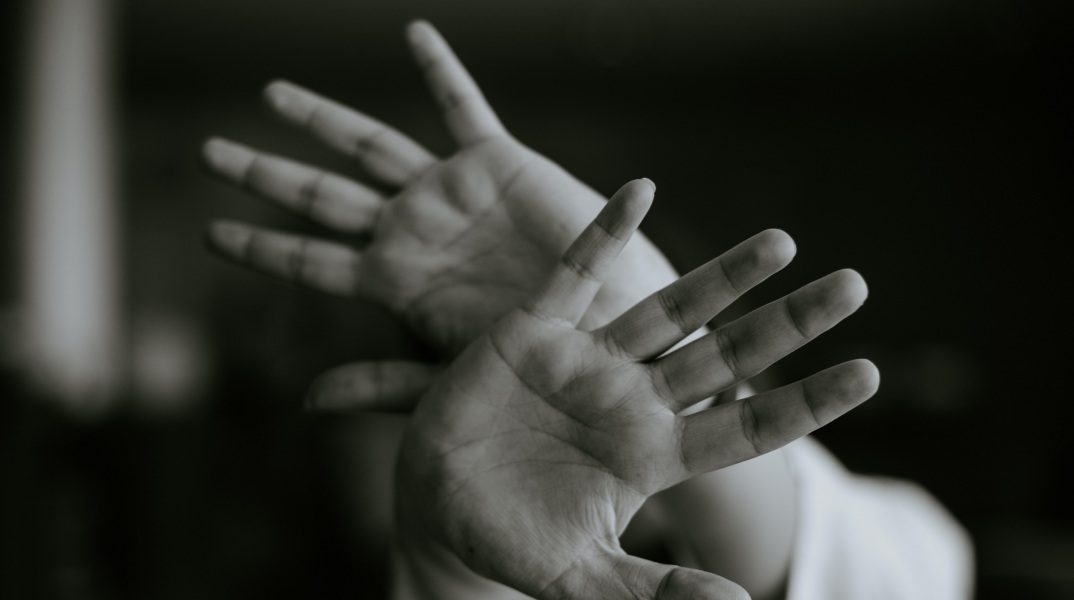 Άτομο με τα χέρια μπροστά στο πρόσωπο - Εικόνα που παραπέμπει στην ανάγκη το άτομα να προστατευτεί και να αποφύγει την επίθεση - κίνδυνο