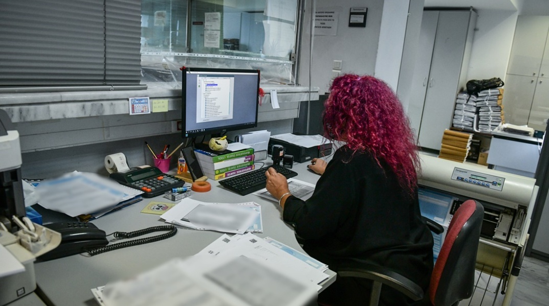 Δημόσιος υπάλληλος εργάζεται στο γραφείο της