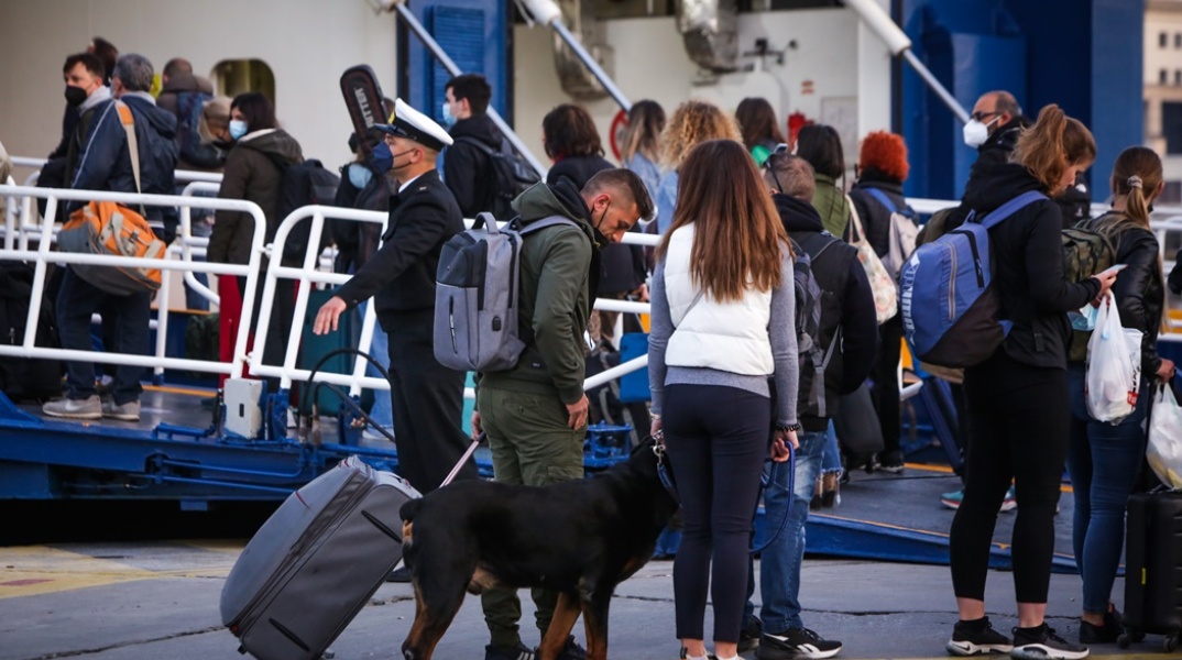 Πολίτες με βαλίτσες και κατοικίδιο στο λιμάνι του Πειραιά αναμένουν την επιβίβασή τους στο πλοίο