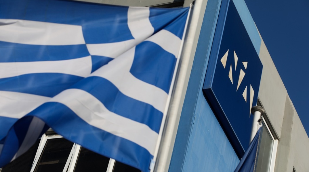 Το λογότυπο της Νέας Δημοκρατίας και η ελληνική σημαία έξω από τα γραφεία του κόμματος στην Πειραιώς