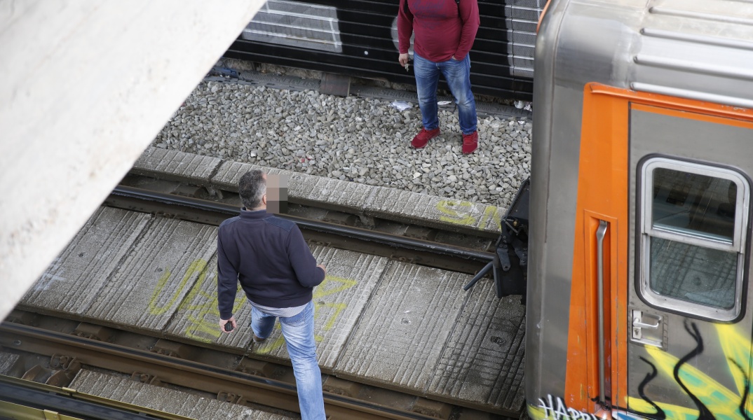 Δύο άνδρες στις γραμμές του Ηλεκτρικού κατά τις προσπάθειες απεγκλωβισμού ατόμου από τις ράγες