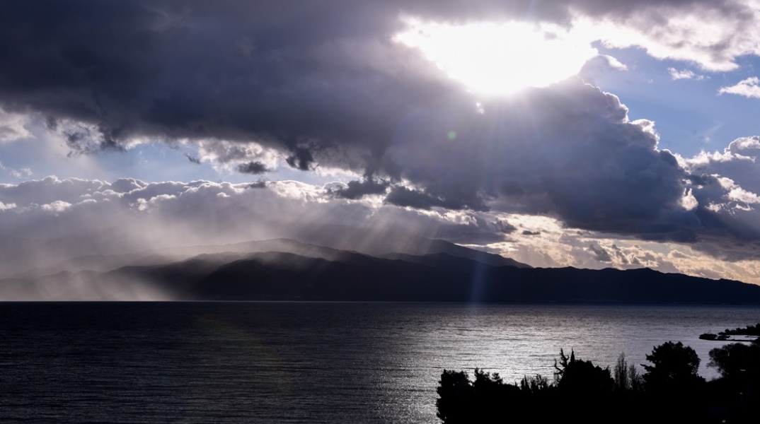 Σύννεφα πάνω από τον ουρανό και ακτίνες του ήλιου που ξεφεύγουν από τα σύννεφα