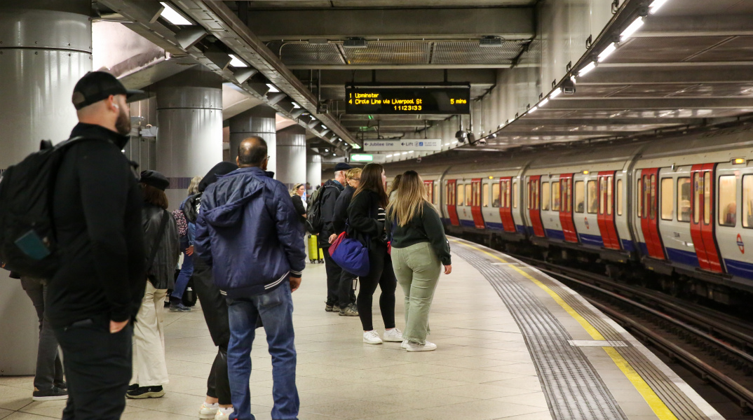 Σταθμός του μετρό στη Βρετανία και επιβάτες που αναμένουν την έλευση του συρμού στην αποβάθρα