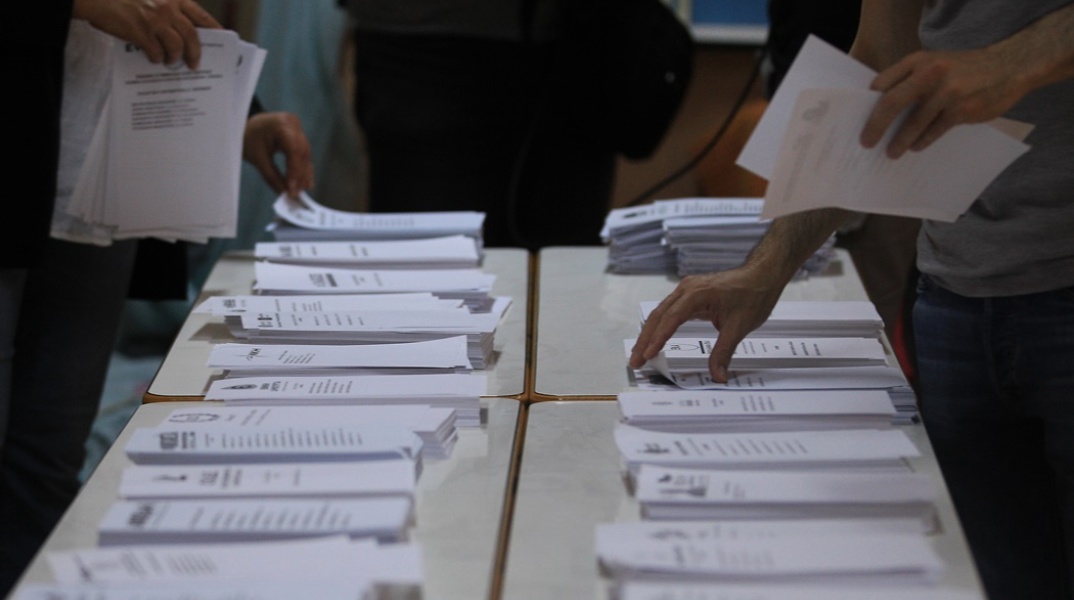 Ψηφοδέλτια των κομμάτων παραταγμένα σε θρανίο εκλογικού κέντρου