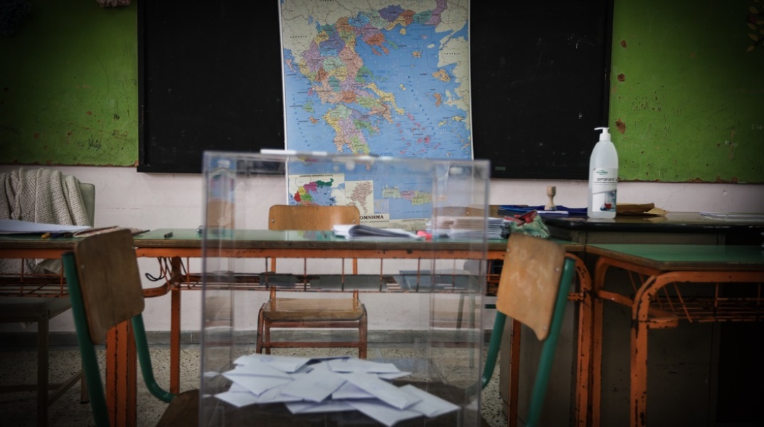 Κάλπη στερεωμένη σε δύο καρέκλες μπροστά από τον χάρτη της Ελλάδας