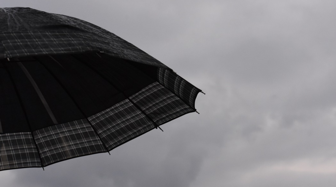 Ομπρέλα με φόντο συννεφιασμένο ουρανό