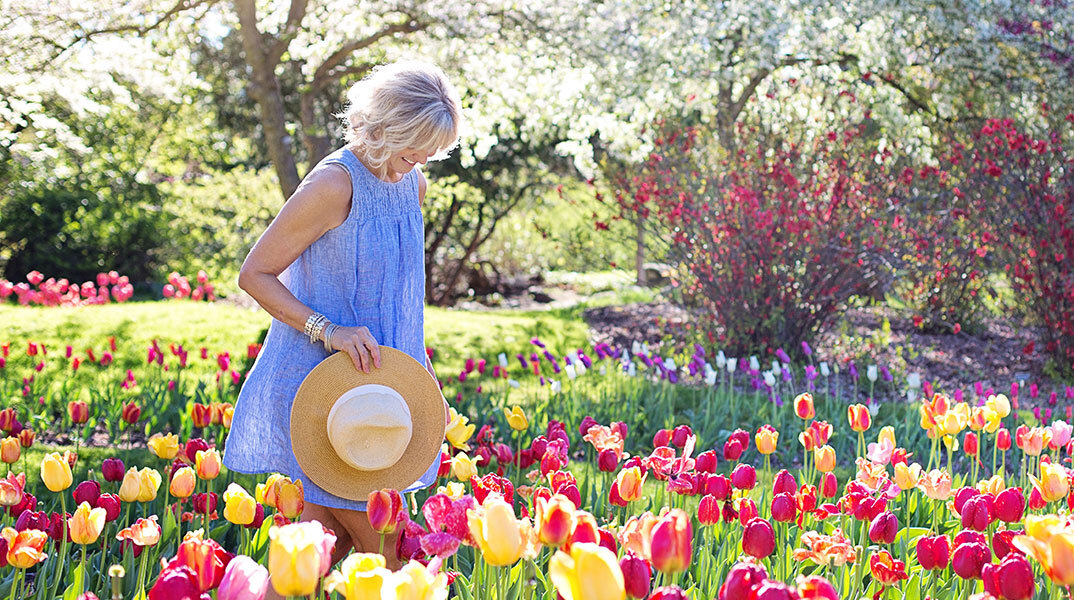 Γυναίκα με άσπρα μαλλιά ανάμεσα σε τουλίπες