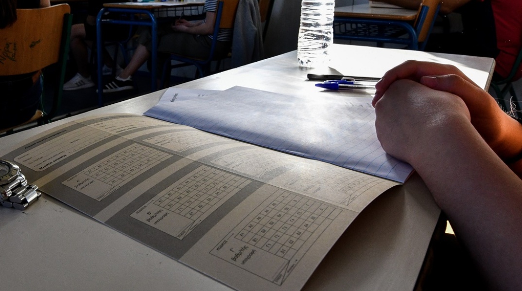 Υποψήφιος των Πανελληνίων Εξετάσεων πάνω από το τετράδιο απαντήσεων