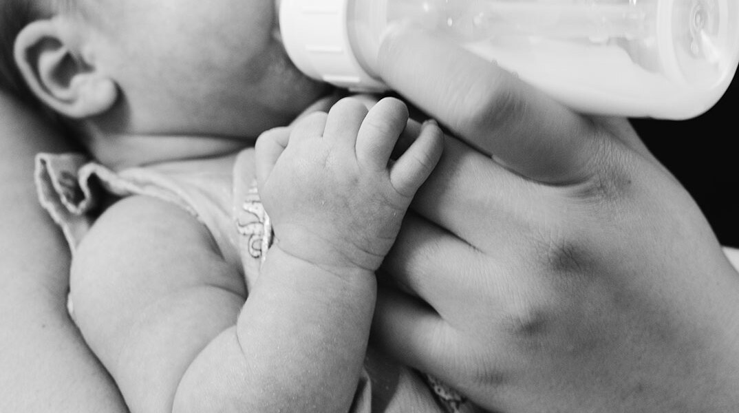Μωρό που πίνει γάλα από μπιμπερό