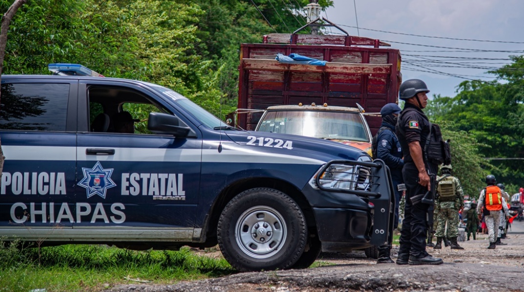 Αστυνομικός στέκεται έξω από περιπολικό όχημα σε δρόμο του Μεξικού