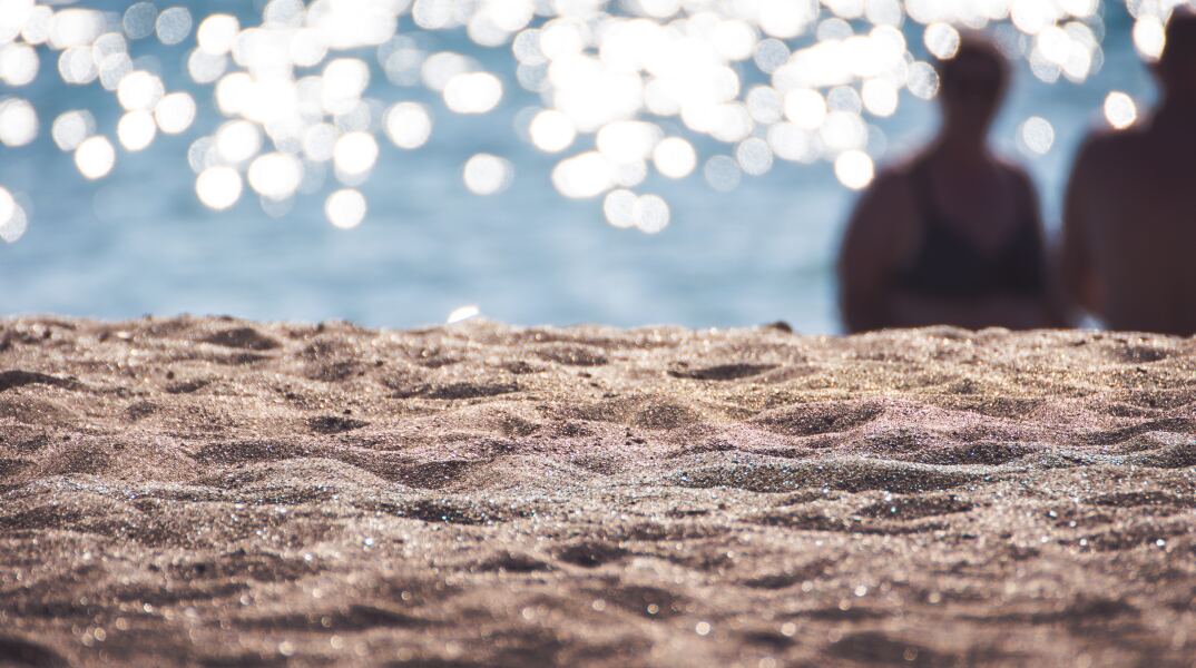 Ακροθαλασσιά στο βάθος διακρίνονται δύο λουόμενοι