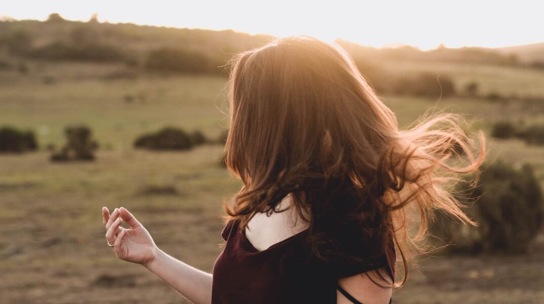 Γυναίκα με καστανά μακριά μαλλιά που ανεμίζουν
