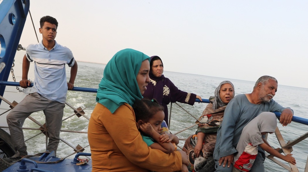 Πολίτες κάθε ηλικίας ταξιδεύουν με πλοιάριο μετά τη φυγή τους από του Σουδάν, λόγω του πολέμου