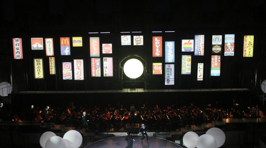 Η παρουσίαση της παράστασης «Μαντάμα Μπατερφλάι» από τον Ολιβιέ Πι και η επιλογή προβολής λογοτύπων πολυεθνικών εταιρειών στον τοίχο του Ηρωδείου.