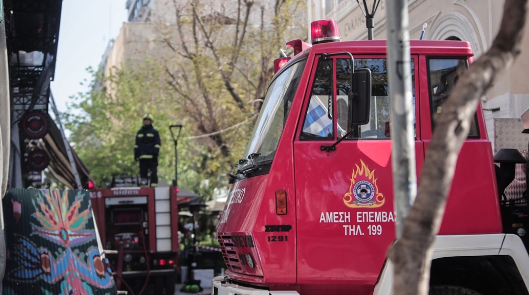 Πυροσβεστικό και γερανοφόρο όχημα επιχειρεί για την κατάσβεση φωτιάς στο κέντρο της Αθήνας