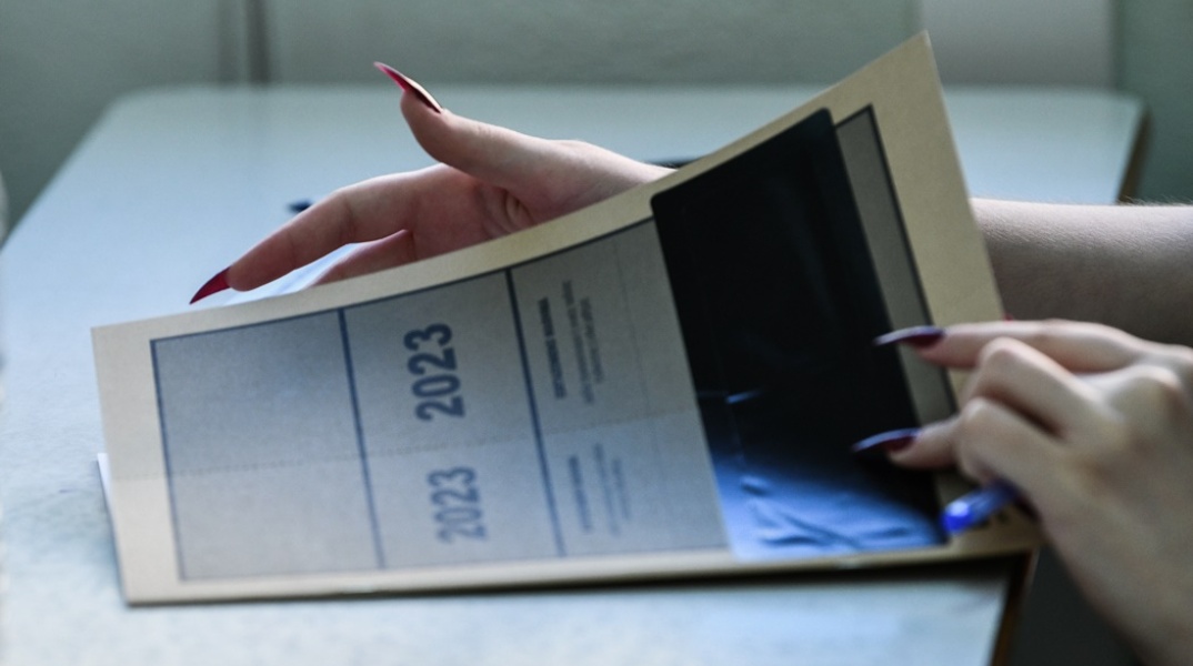 Υποψήφια των Πανελληνίων κρατά στα χέρια της το τετράδιο απαντήσεων των Πανελληνίων