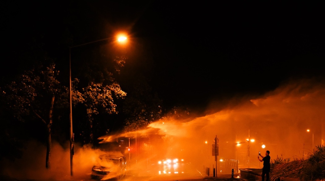 Φλεγόμενο λεωφορείο και πυροσβέστες που επιχειρούν για την ολοκληρωτική κατάσβεσή του