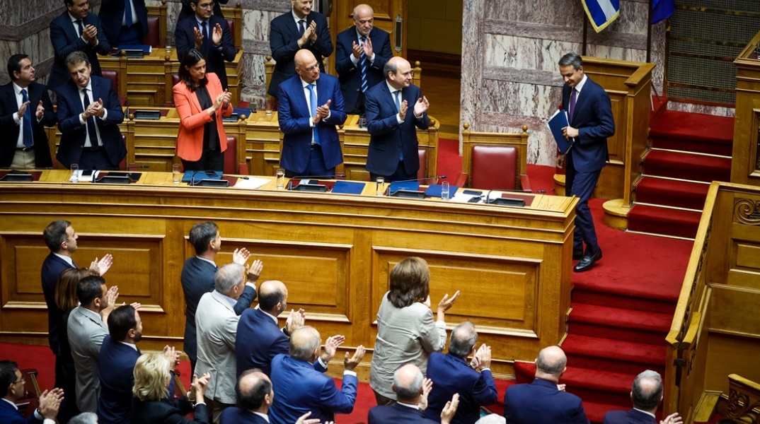 Όρθιοι υπουργοί και βουλευτές χειροκροτούν τον πρωθυπουργό Κυριάκο Μητσοτάκη μετά την ομιλία του επί των προγραμματικών δεσμεύσεων