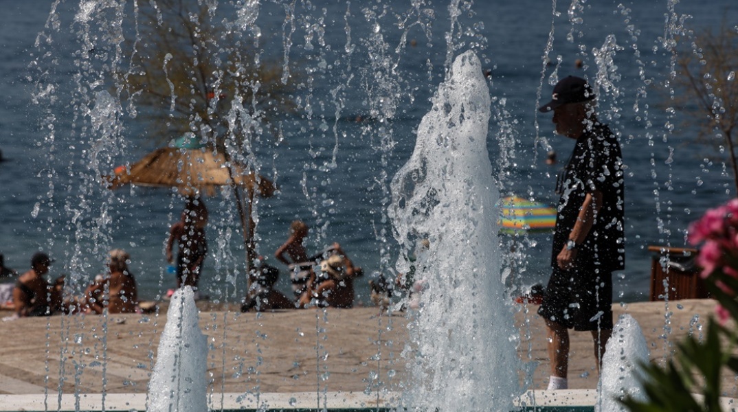 Άτομα σε παραλία διακρίνονται πίσω από σιντριβάνι στην περιοχή του Παλαιού Φαλήρου