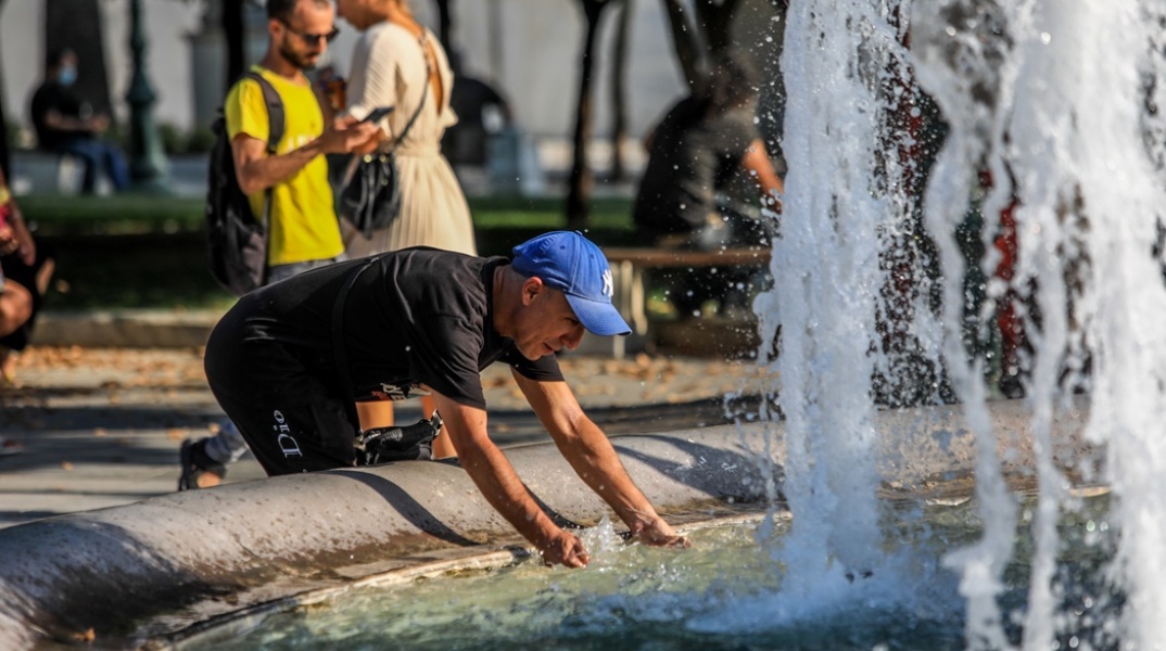 Άνδρας βουτά τα χέρια του στο σιντριβάνι στο Σύνταγμα για να δροσιστεί εν μέσω καύσωνα