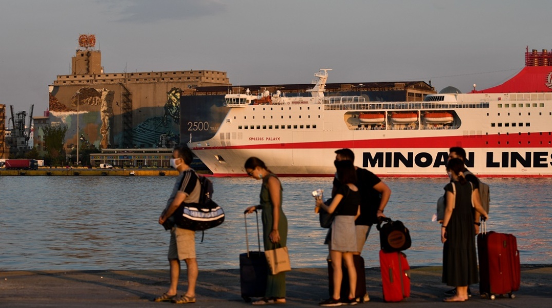 Επιβάτες με βαλίτσες ανά χείρας αναμένουν την επιβίβασή τους σε πλοίο