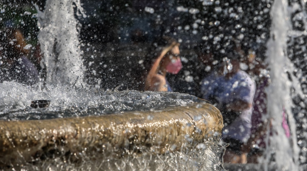 Γυναίκα διακρίνεται πίσω από σιντριβάνι της πλατείας Συντάγματος