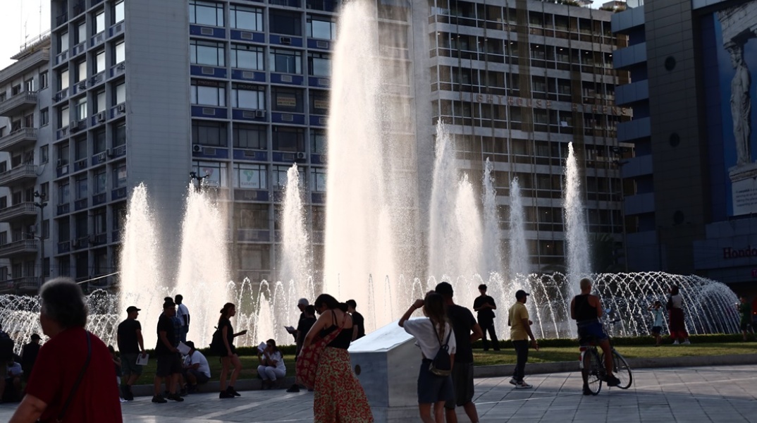 Πολίτες στην πλατεία Ομονοίας και τη δροσιά του σιντριβανιού