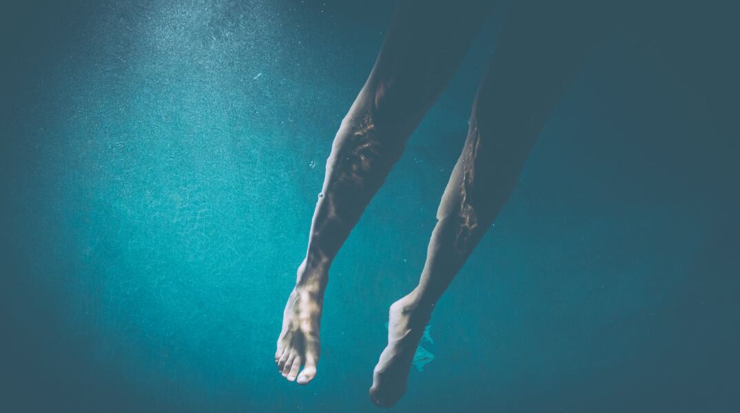 Τα πόδια ατόμου στη θάλασσα 