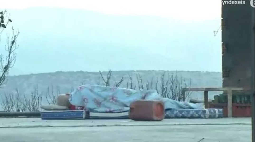 Άνδρας κοιμάται πάνω στο καμένο σπίτι του στη Μάνδρα