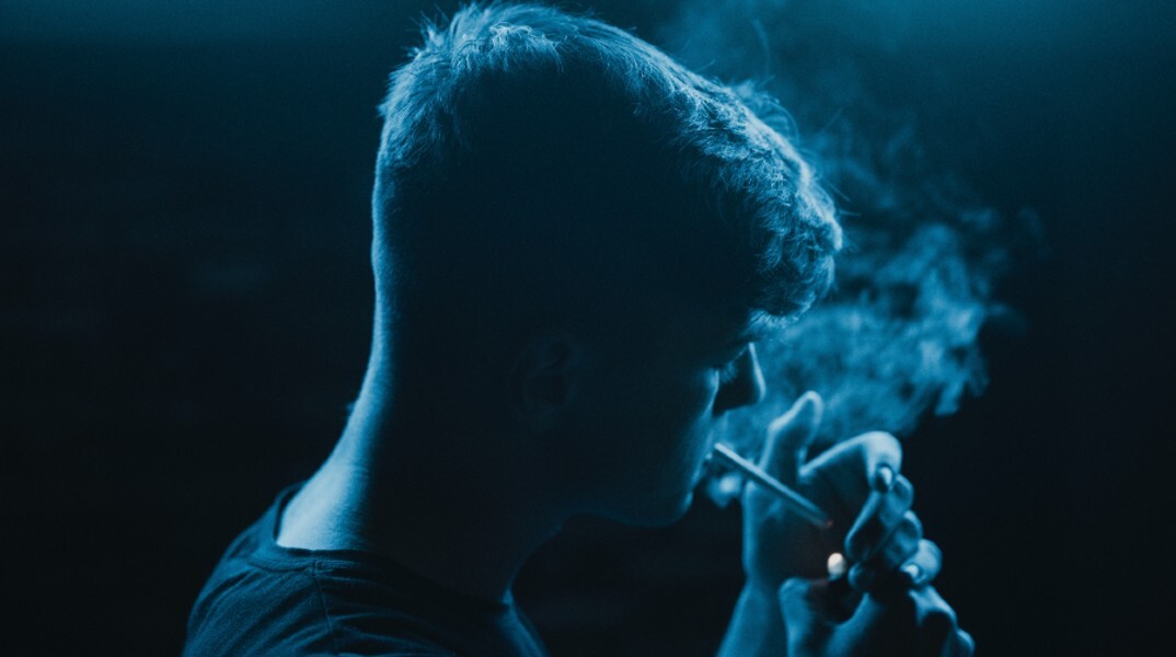 Νεαρός άνδρας καπνίζει