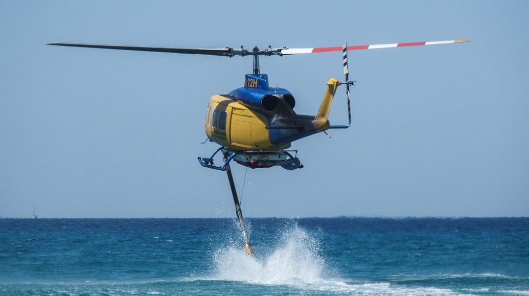 Ελικόπτερο συλλέγει νερό από τη θάλασσα και επιχειρεί για την κατάσβεση φωτιάς