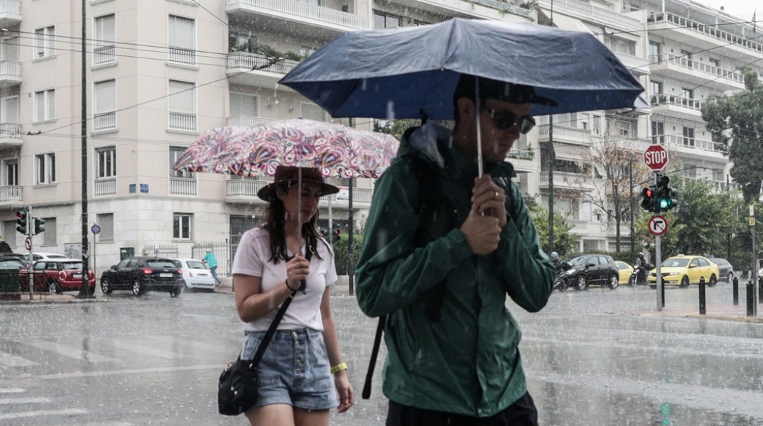 Πολίτες με ομπρέλα στο κέντρο της Αθήνας μετά από ξαφνικό μπουρίνι
