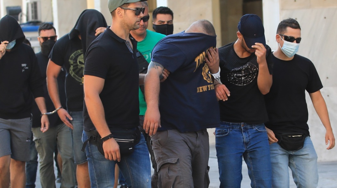 Οι συλληφθέντες κρύβουν το πρόσωπό τους προσερχόμενοι στο γραφείο του εισαγγελέα για τη δολοφονία του Μιχάλη Κατσουρή