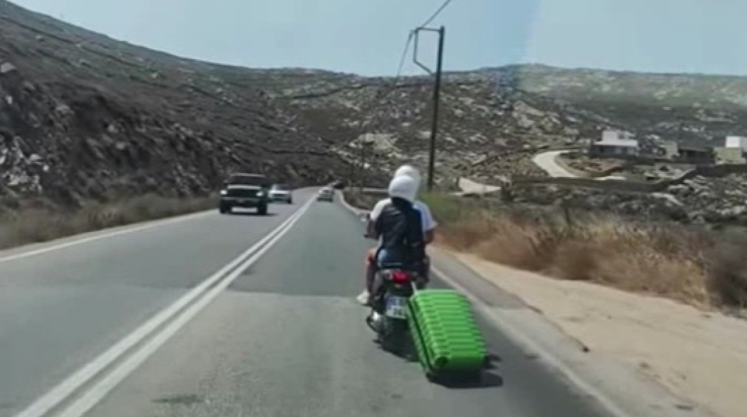 Μύκονος: Τουρίστας έσερνε με σκούτερ βαλίτσα με ροδάκια - Κυκλοφορούσαν σε κεντρικό δρόμο του νησιού με την αποσκευή δεμένη στο πίσω μέρος της μηχανής.