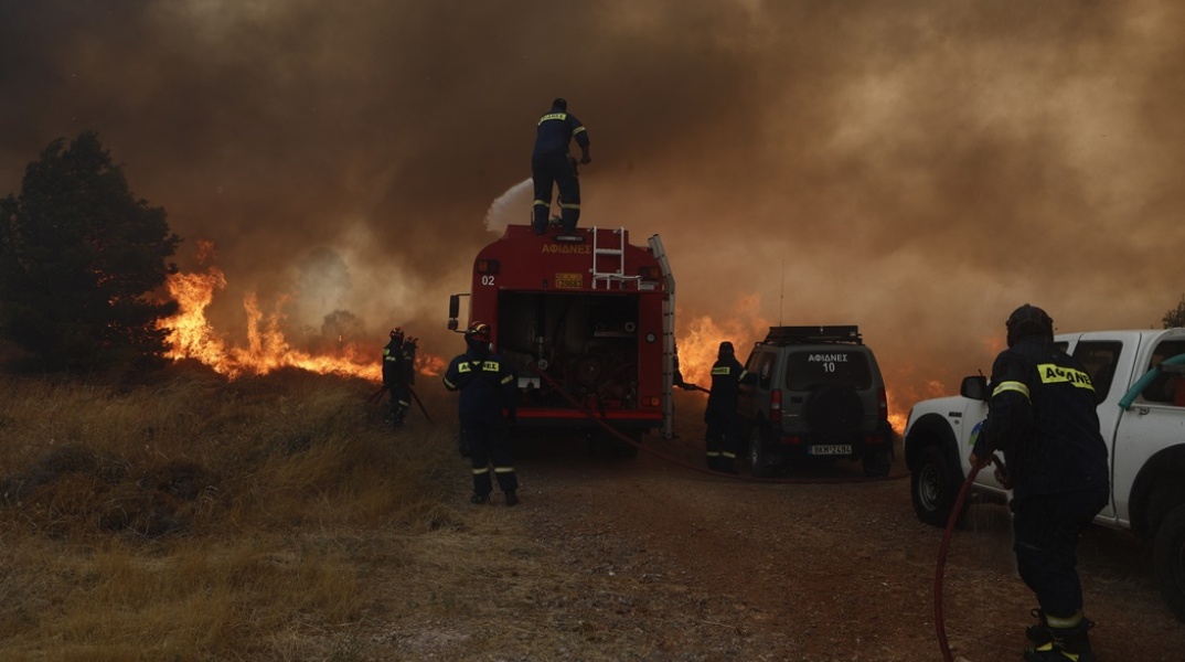 Πυροσβέστες με τα οχήματά τους επιχειρούν για την κατάσβεση της φωτιάς στην Πάρνηθα