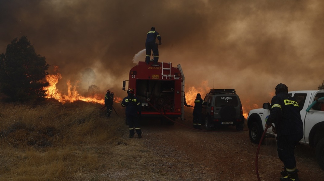 Πυροσβέστες με τα οχήματά τους επιχειρούν για την κατάσβεση της φωτιάς στην Πάρνηθα