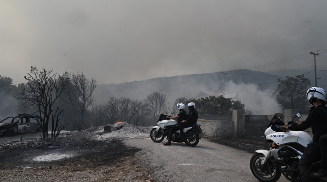 Αστυνομικοί σε σημείο από όπου έχει περάσει η φωτιά στην Πάρνηθα