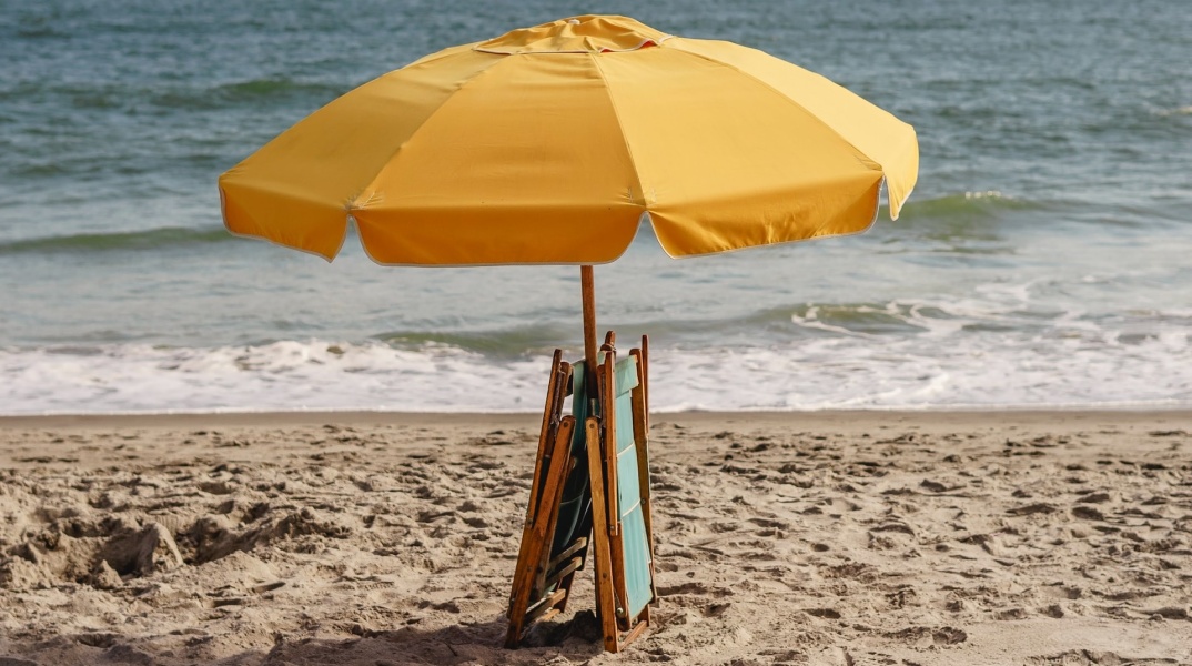 Ομπρέλα και ξαπλώστρες μαζεμένα σε παραλία