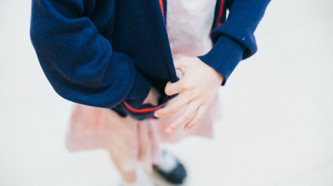 Παιδάκι που φορά στολή στο σχολείο - Διακρίνονται τα ρούχα και τα χεράκια του