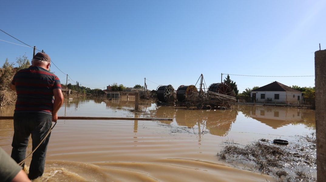Πλημμύρες στη Θεσσαλία και άνθρωποι που περπατούν στα νερά ή είναι μέσα σε βάρκα