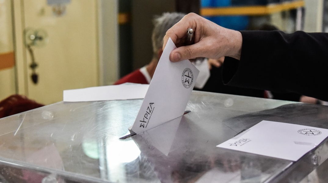 Ψηφοδέλτιο των εσωκομματικών εκλογών του ΣΥΡΙΖΑ που φέρει το έμβλημα του κόμματος και χέρι που το ρίχνει στην κάλπη