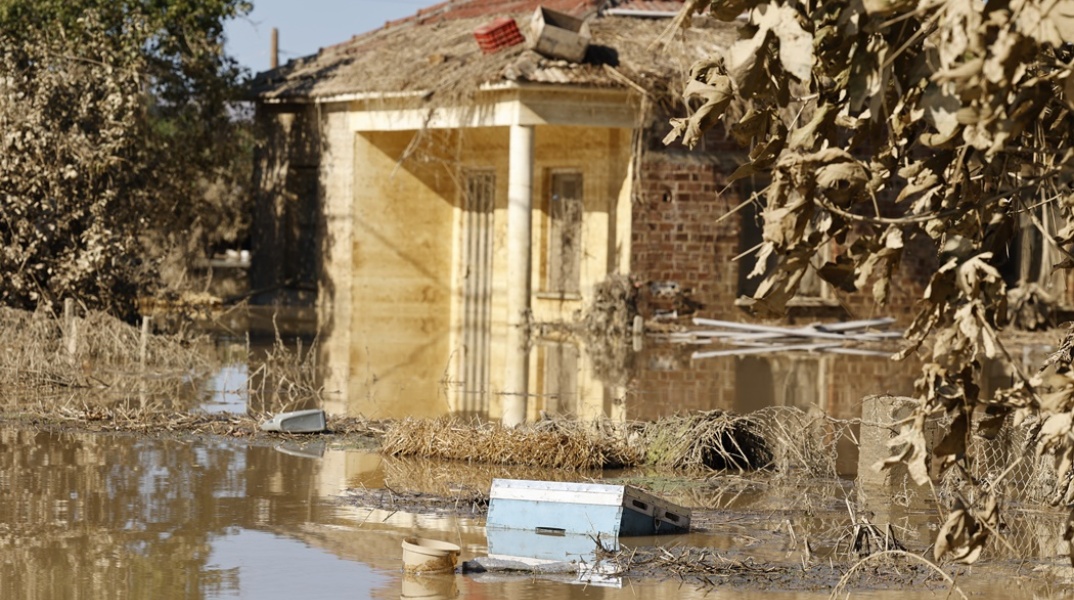 Πλημμυρισμένη αυλή σπιτιού στη Θεσσαλία και κτίριο που παραμένει ορατό από τα νερά