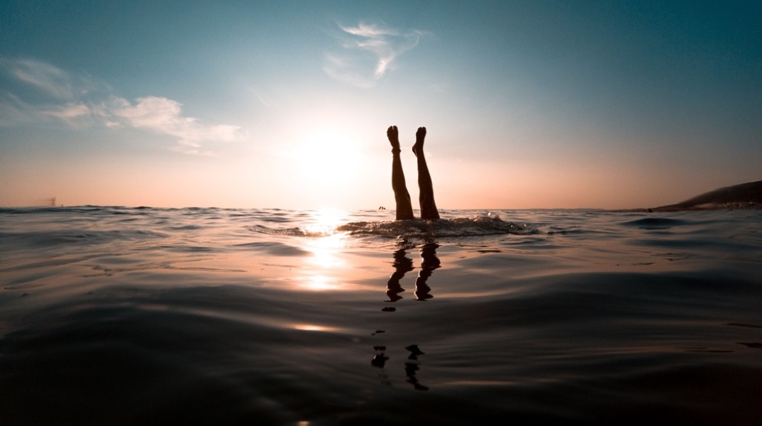 Άτομο βουτά στη θάλασσα και διακρίνονται μόνο τα πόδια του